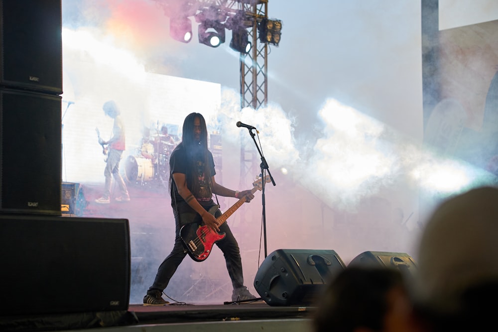 a person with a guitar on a stage