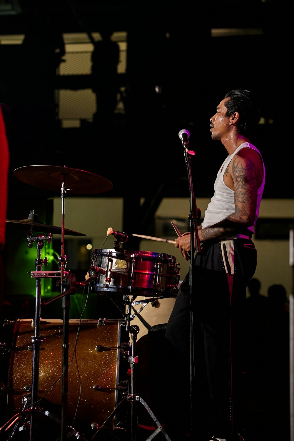 a man with a tattoo on his arm playing drums