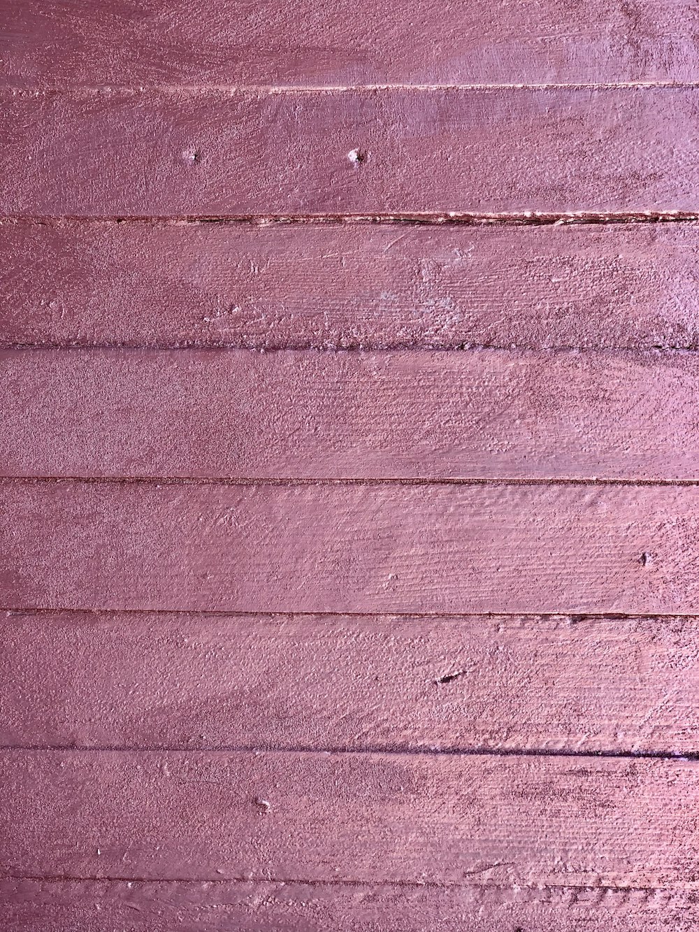 a close up of a pink painted wall