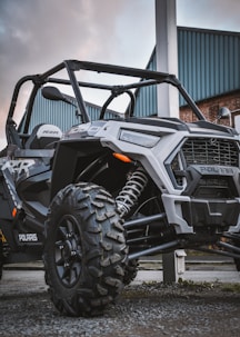 a polaris rzr xp4 is parked in front of a building