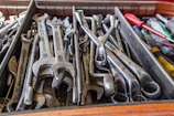 Heavy-duty wrench lying next to a toolbox filled with various hand tools.