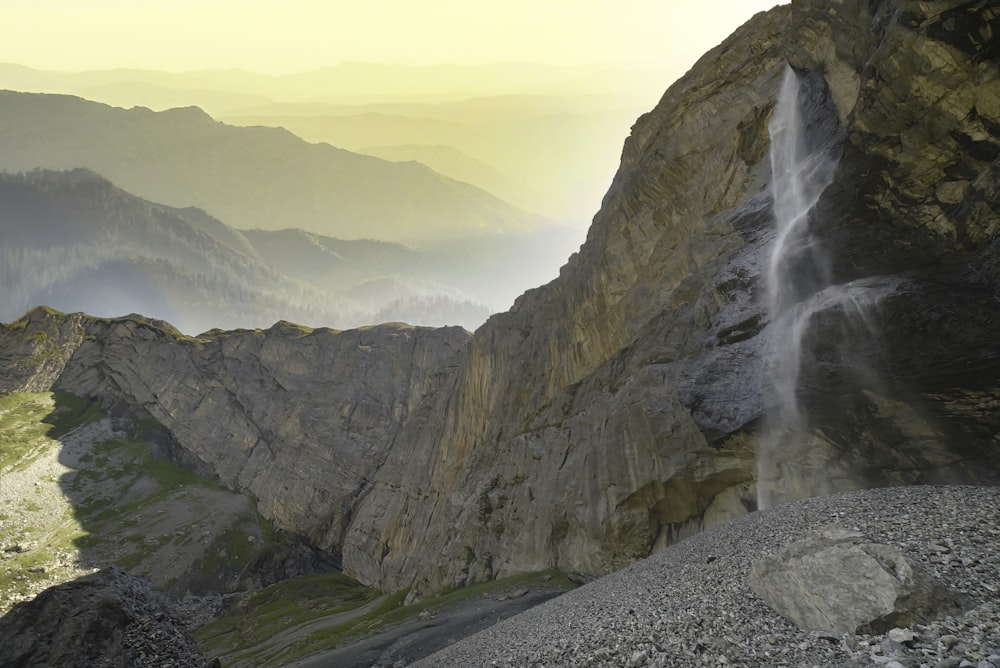 a very tall waterfall in the middle of a mountain