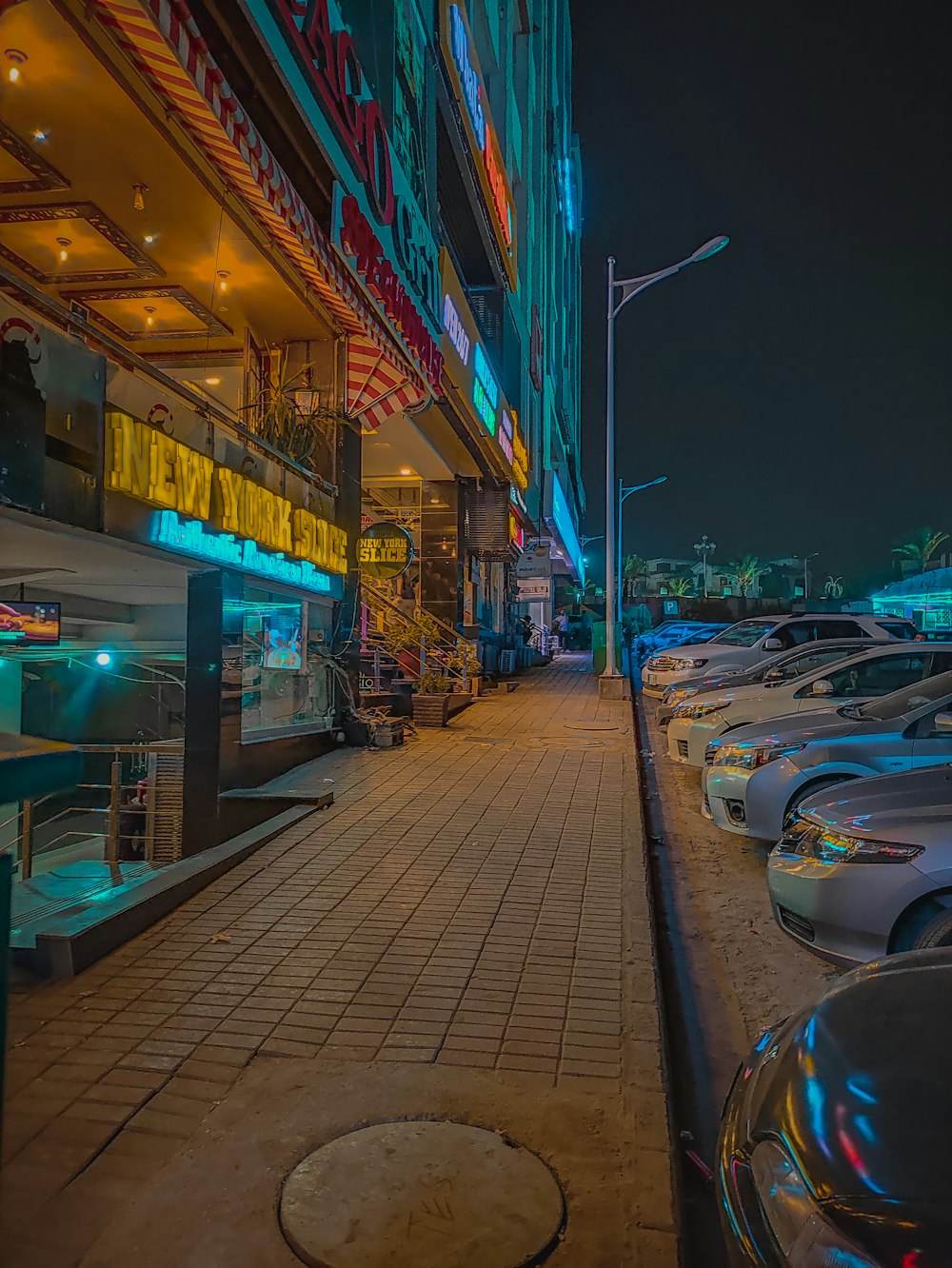 a row of parked cars sitting next to a tall building