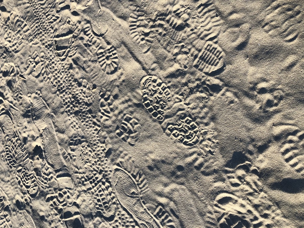 a close up of sand with footprints on it