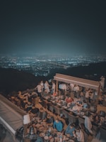 a group of people sitting around a table on top of a hill