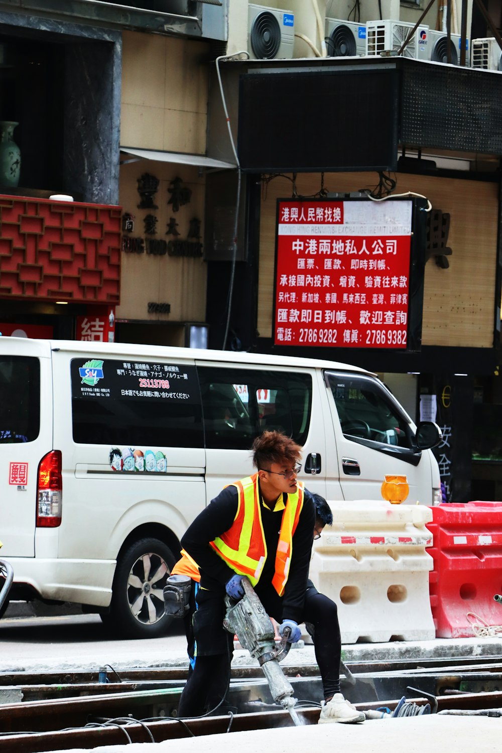 a man in a safety vest is skateboarding down the street