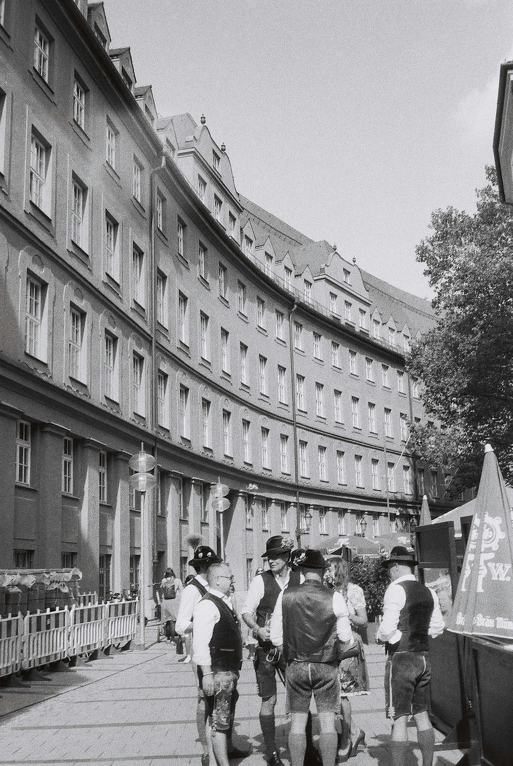 Un groupe d’hommes marchant dans une rue à côté de grands immeubles