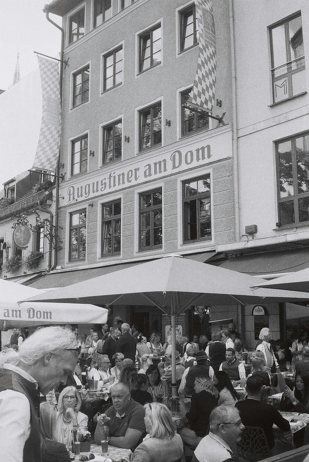 une photo en noir et blanc de personnes mangeant à l’extérieur