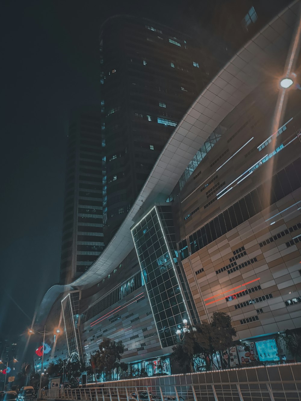 a city street at night with tall buildings