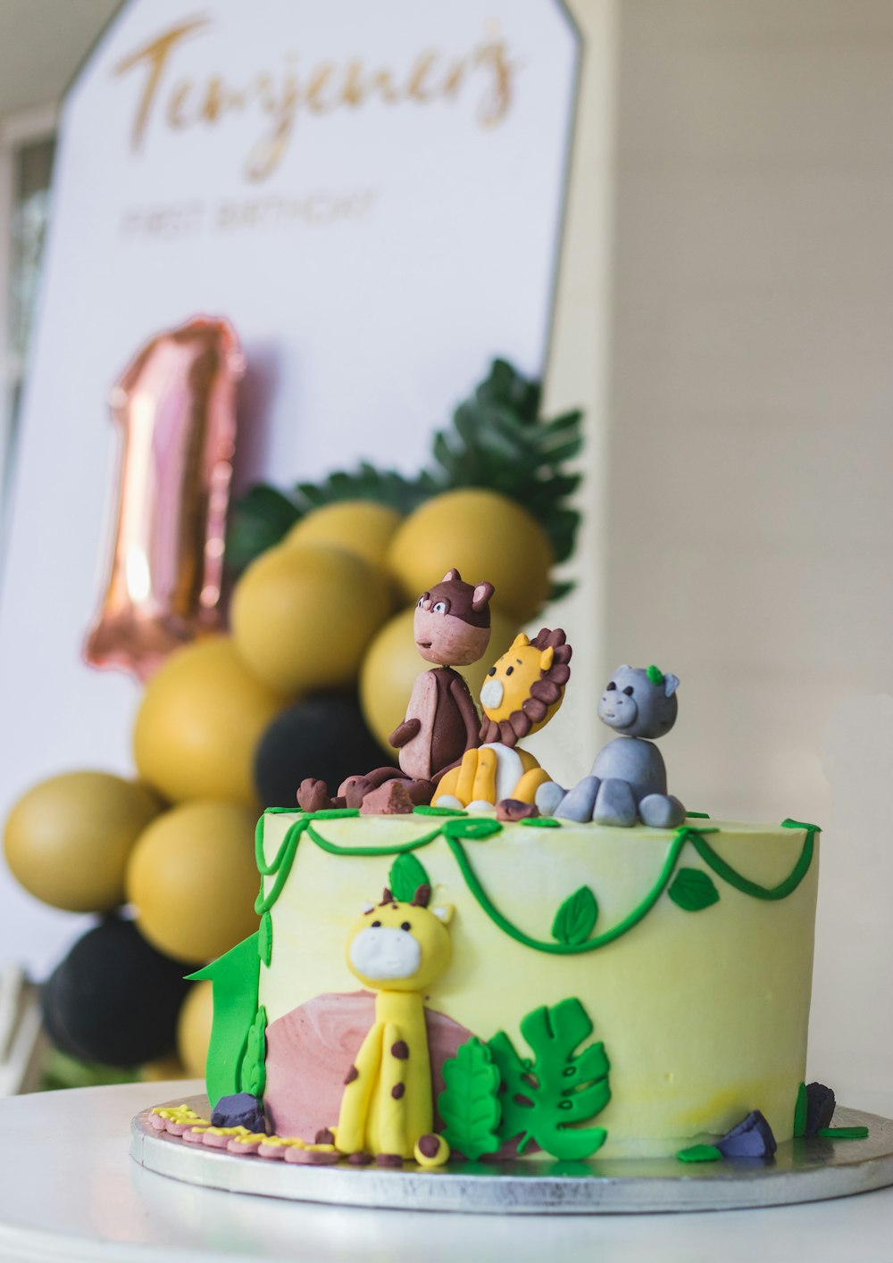 a yellow and green cake with animals on it