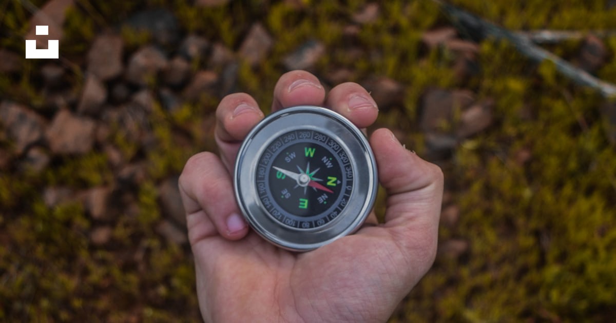 A person holding a compass in their hand photo – Free Compass Image on ...