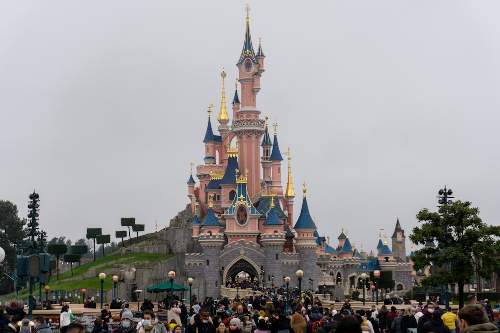 a crowd of people standing in front of a castle