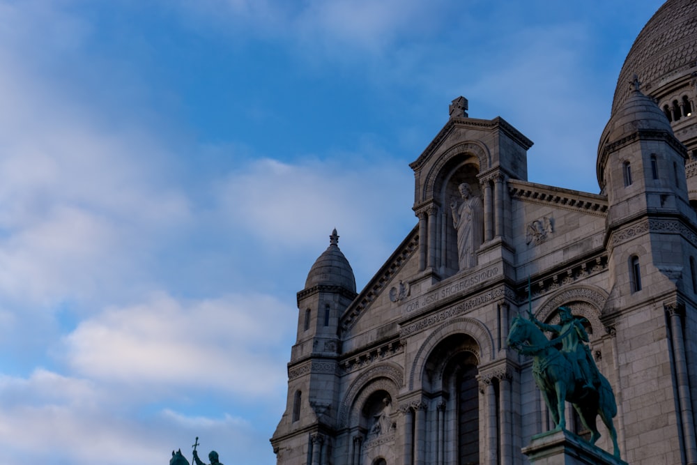 um edifício com uma estátua de um cavalo e cavaleiro em frente a ele