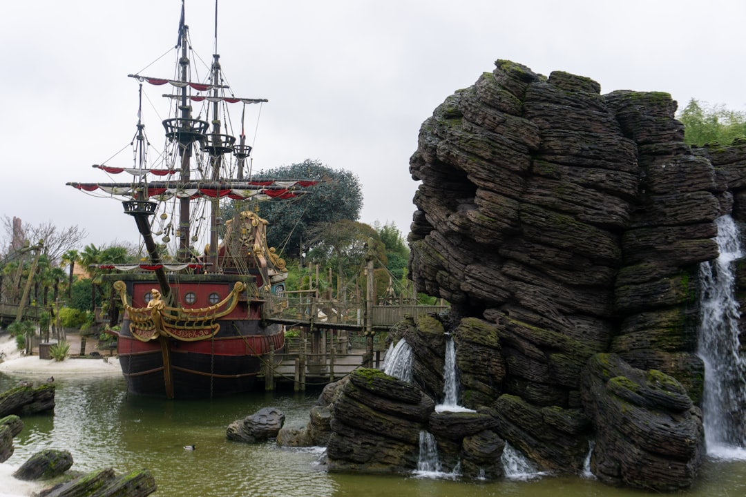 a pirate ship in the water near a waterfall,