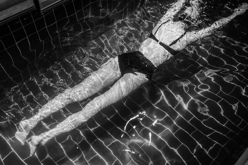 una donna in un costume da bagno che galleggia in una piscina