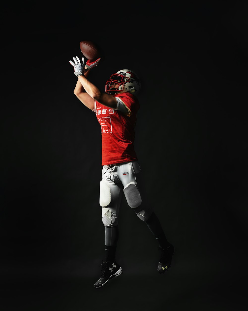 a football player is jumping in the air to catch a ball