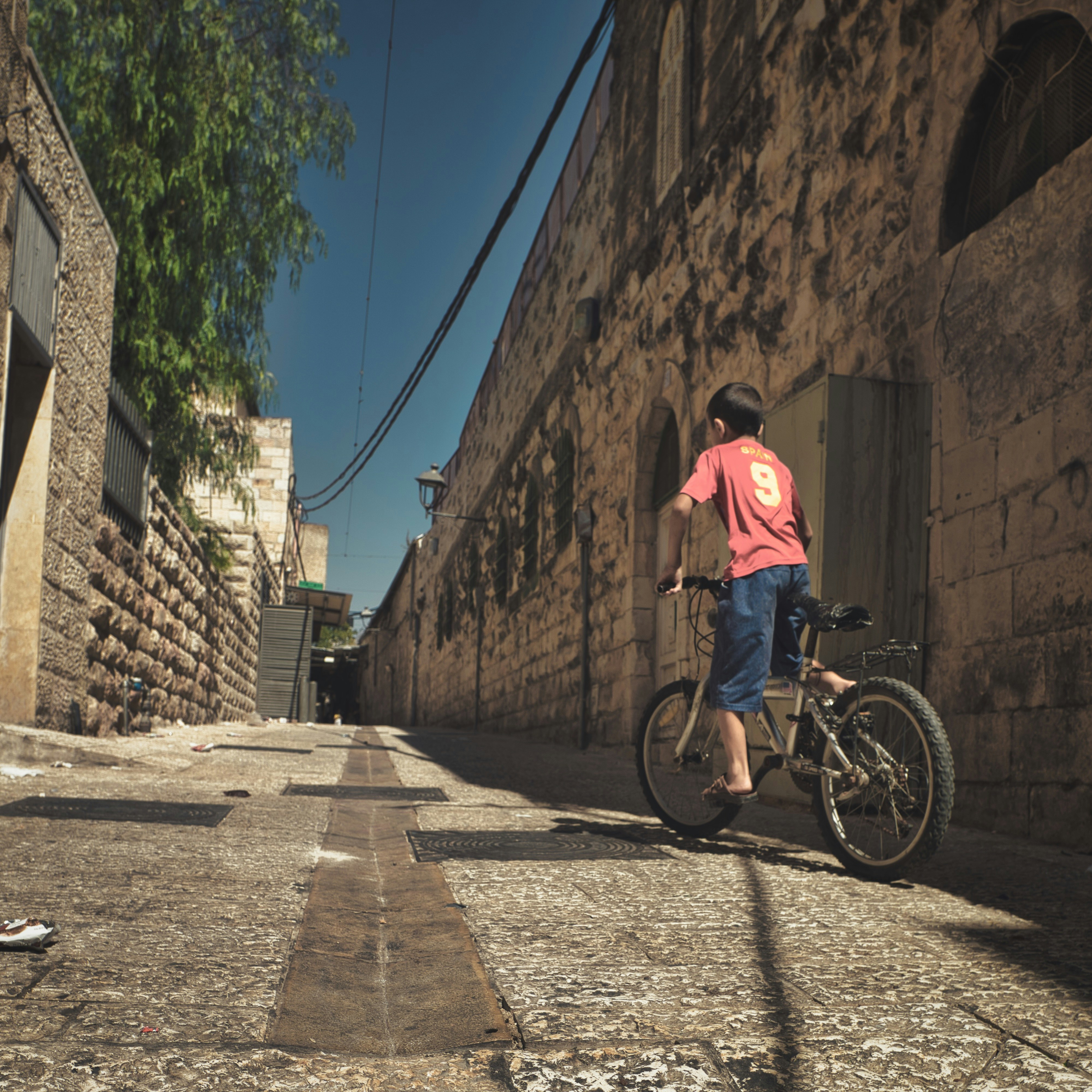 a young boy riding a bike down a street