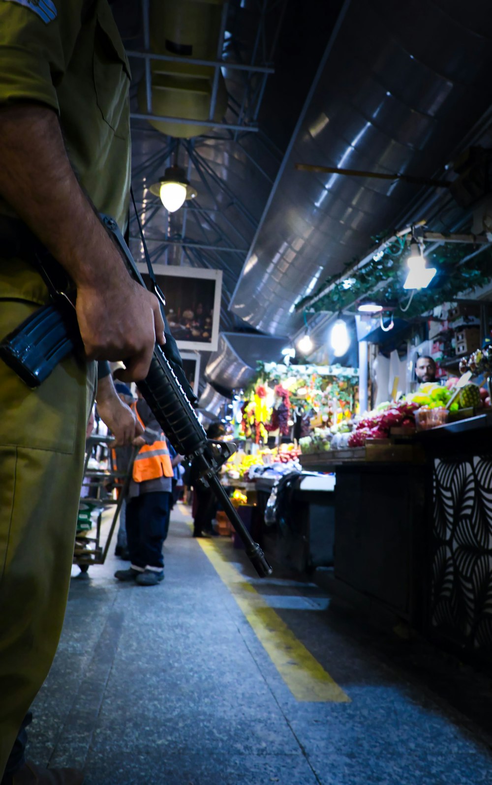 um homem segurando uma arma em um mercado