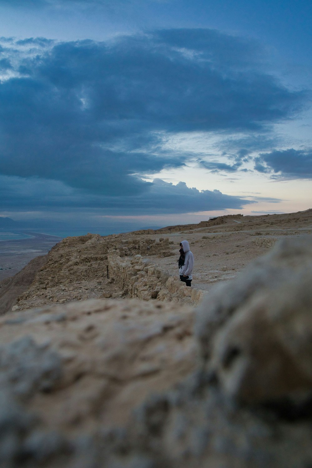 a person sitting on a rock in the desert