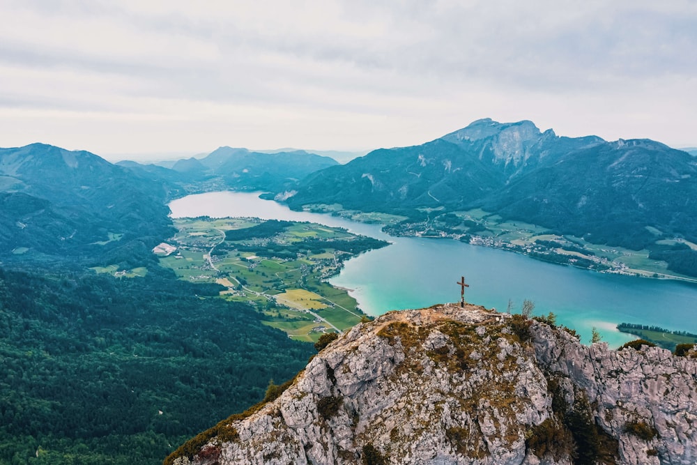 a person standing on top of a mountain overlooking a lake