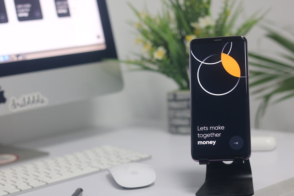 a cell phone sitting on top of a desk next to a computer