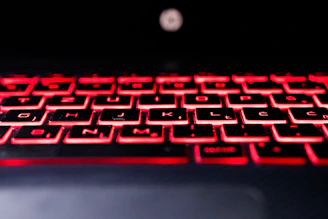A sleek, modern keyboard with red backlighting on a pristine white background, showcasing premium design.