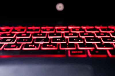 A sleek, modern keyboard with red backlighting on a pristine white background, showcasing premium design.
