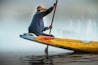 a person sitting on a yellow boat with a paddle