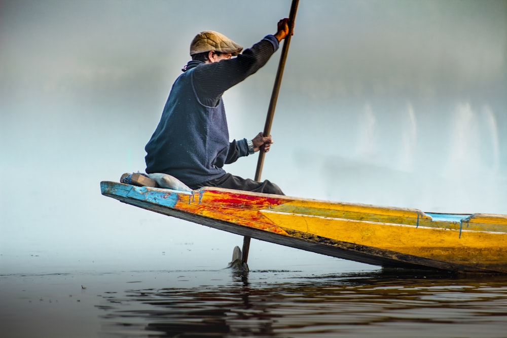 a person sitting on a yellow boat with a paddle