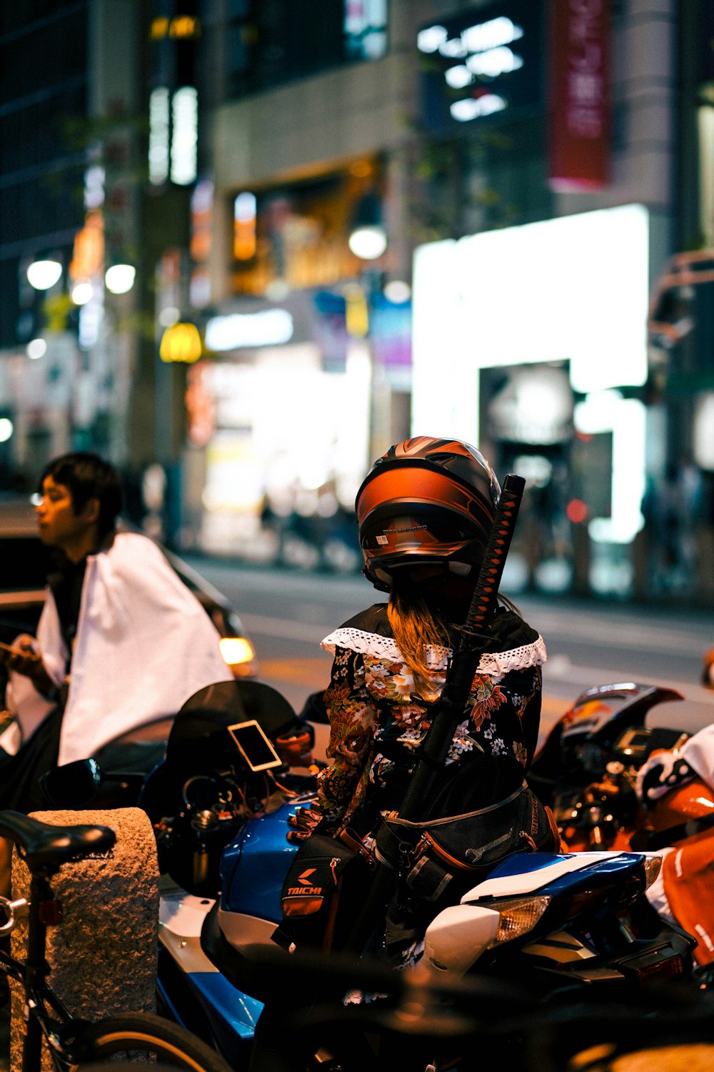 a person sitting on a motorcycle on a city street