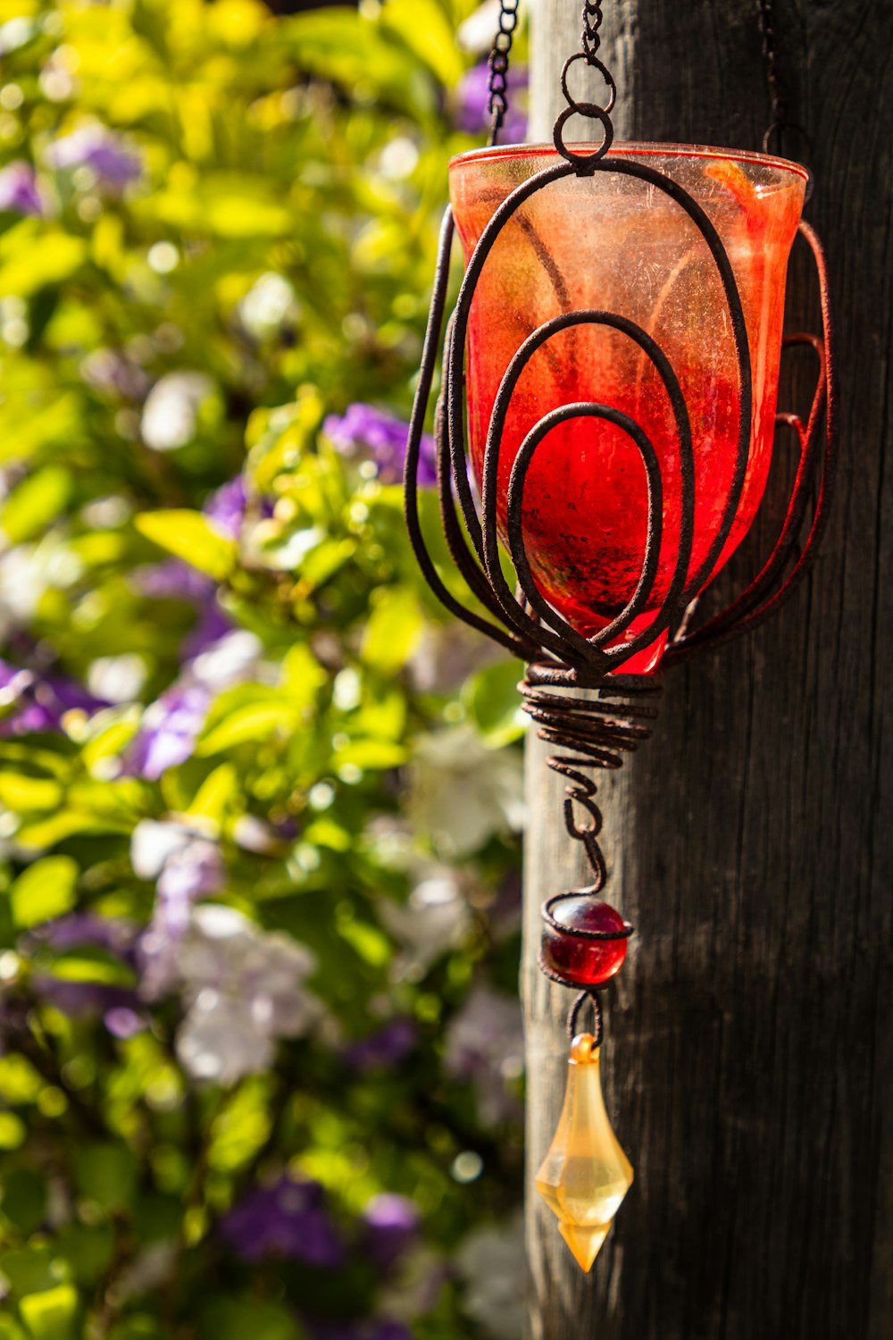a red glass hanging from a wooden post