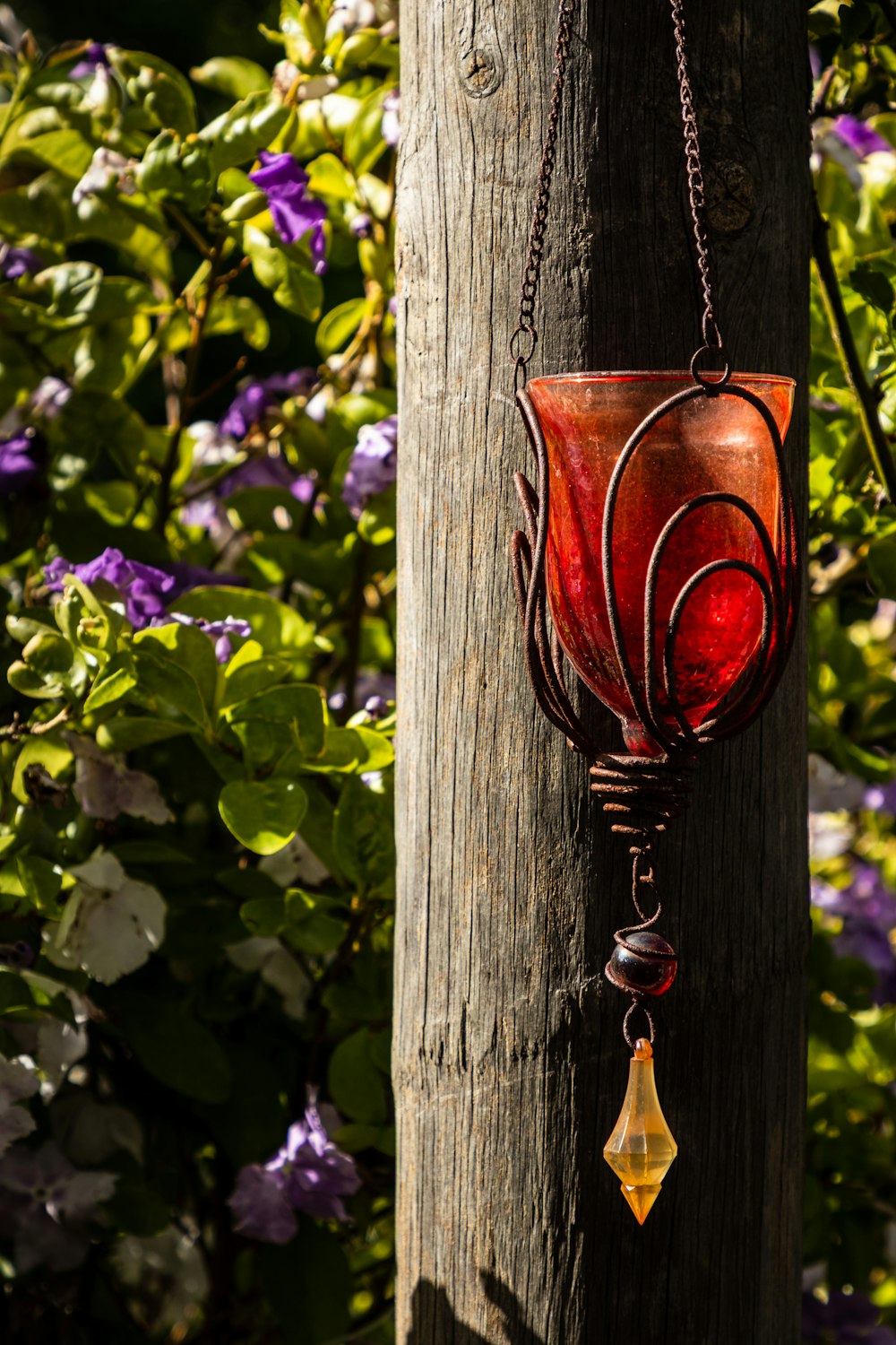 a red glass hanging from a wooden pole
