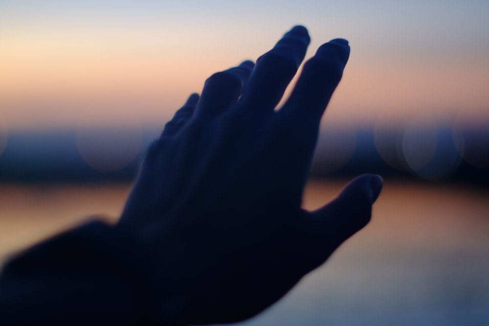 a blurry photo of a person's hand reaching up
