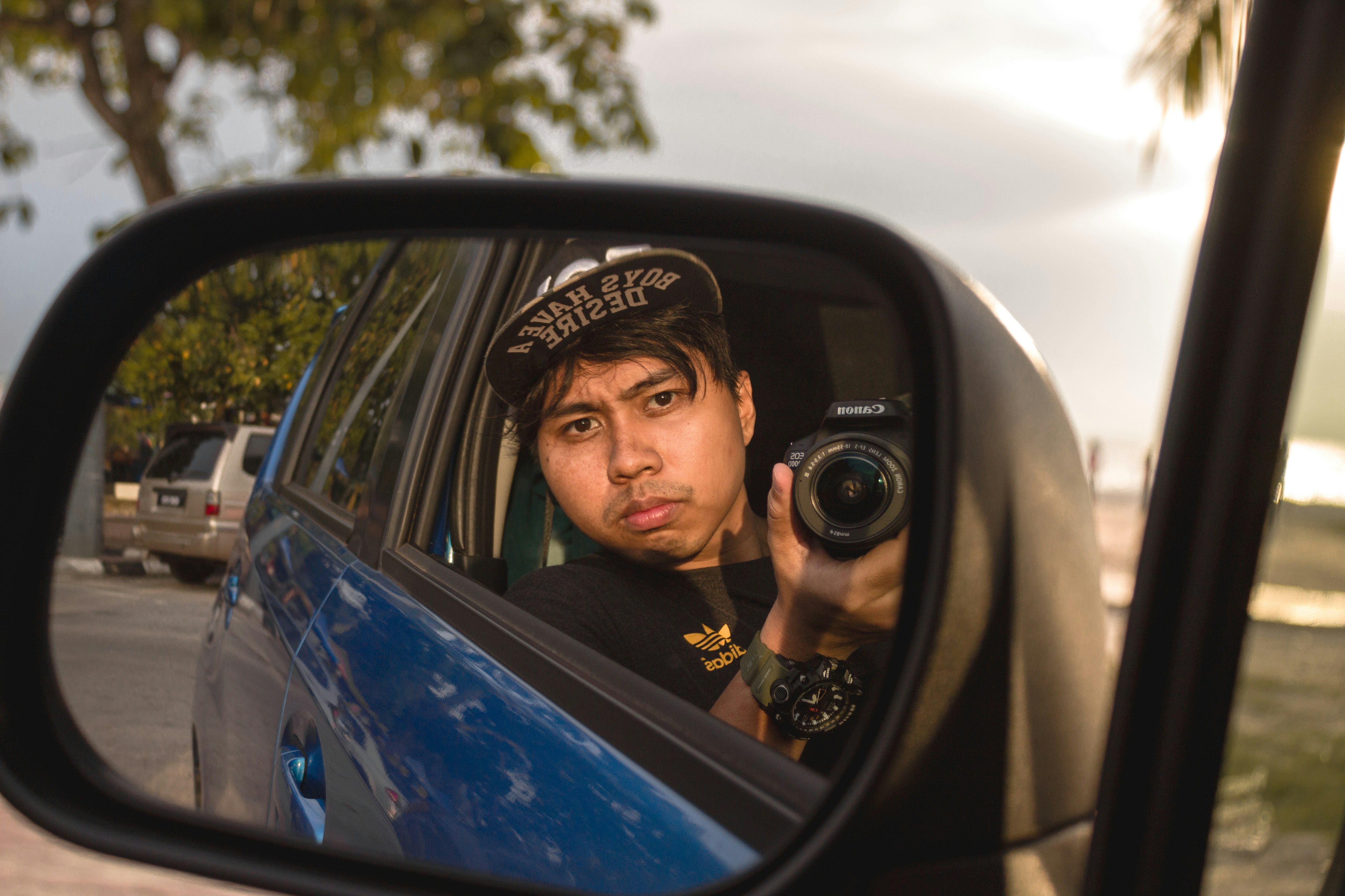 a woman taking a picture of herself in a car mirror
