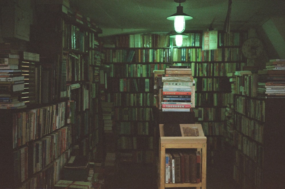 a room filled with lots of books and a lamp