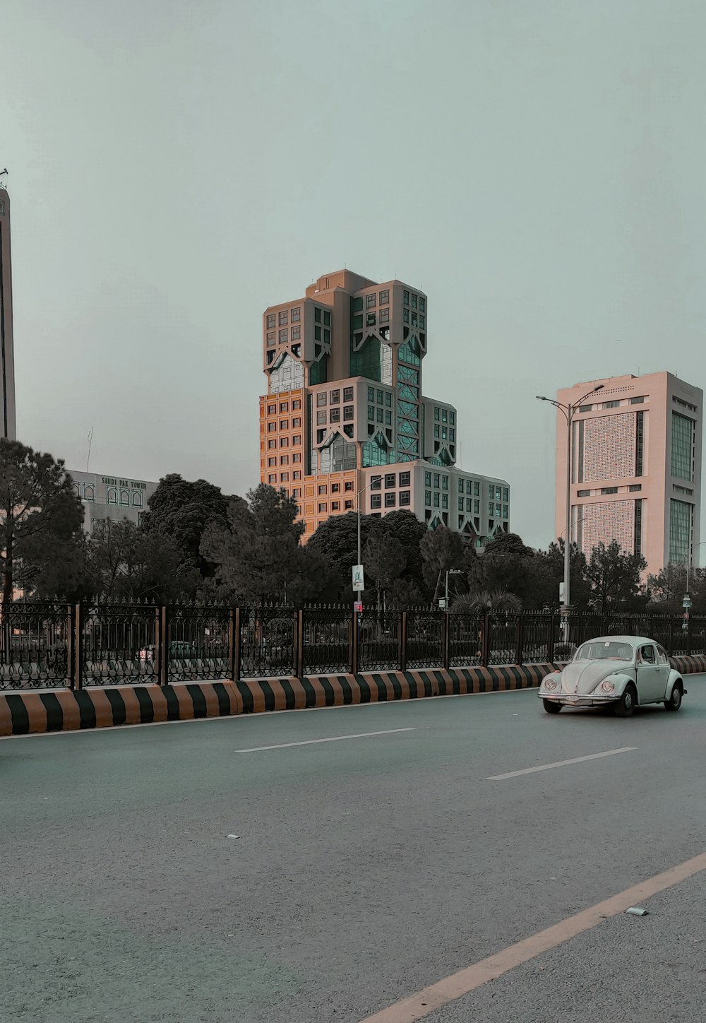 a white car driving down a street next to tall buildings