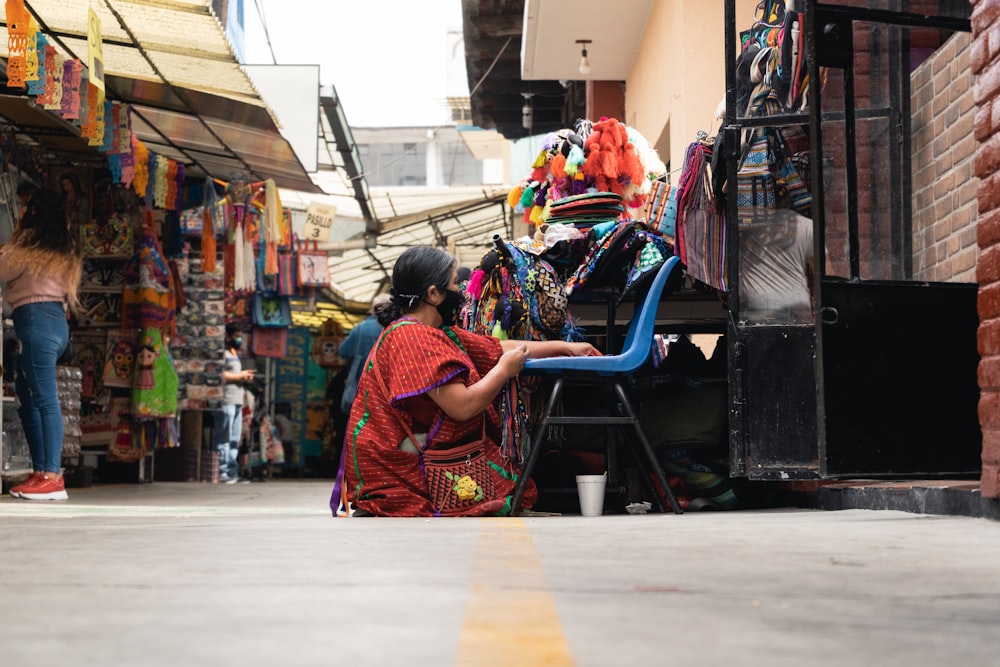 a woman sitting on a chair in a market