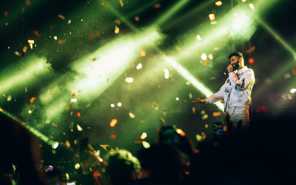 a man standing on top of a stage holding a microphone