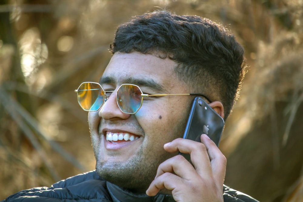 a man wearing sunglasses talking on a cell phone