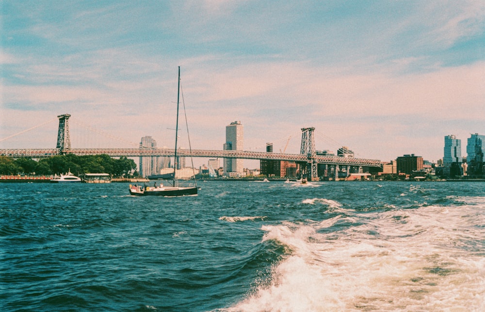 a boat traveling down a river next to a bridge