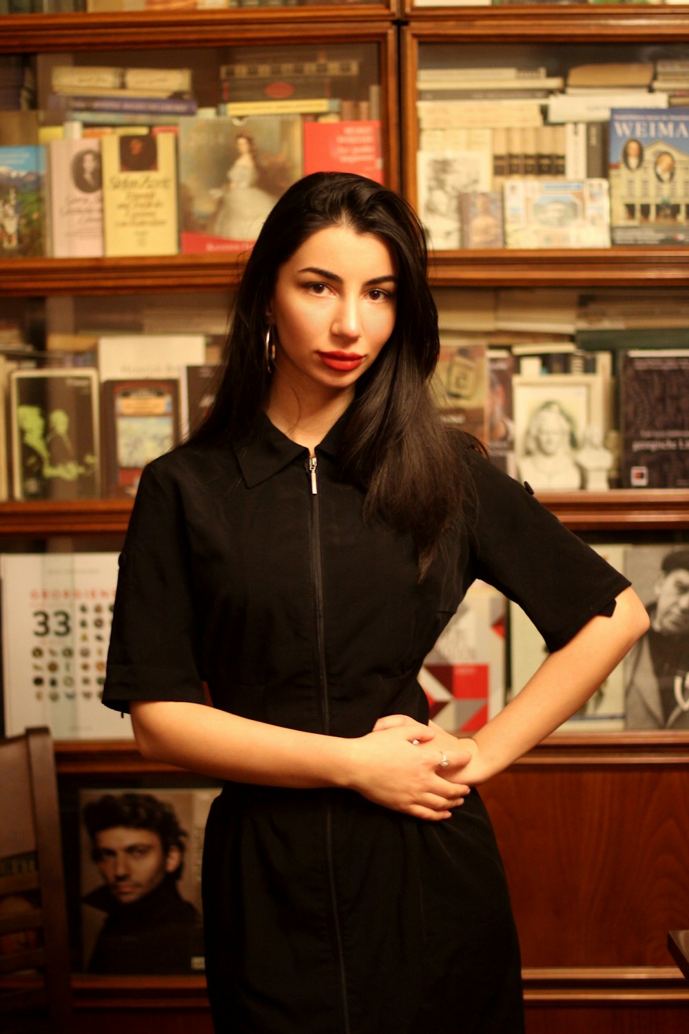 a woman standing in front of a book shelf