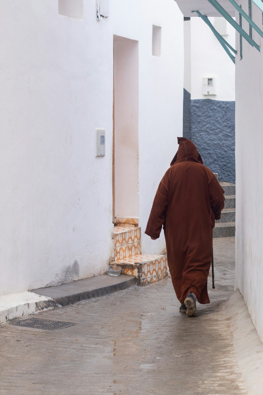 a person in a brown robe walking down a street