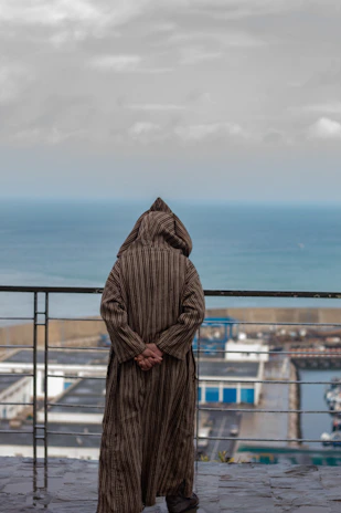 a person standing on a balcony looking out at the ocean
