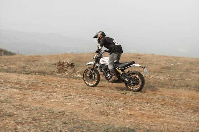 a man riding a dirt bike on a dirt road