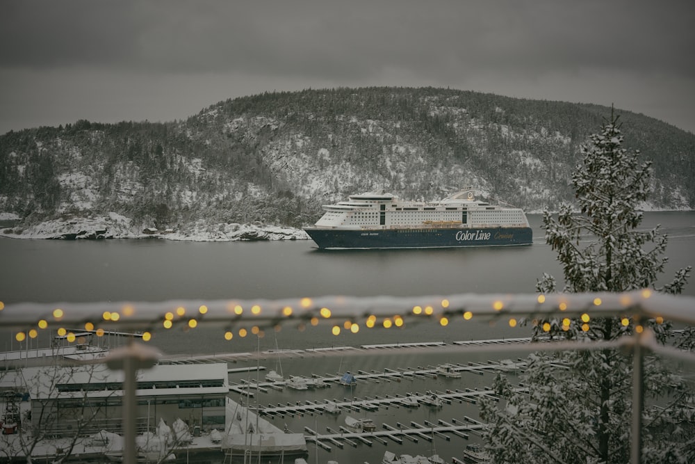 a cruise ship in the water with a snowy mountain in the background