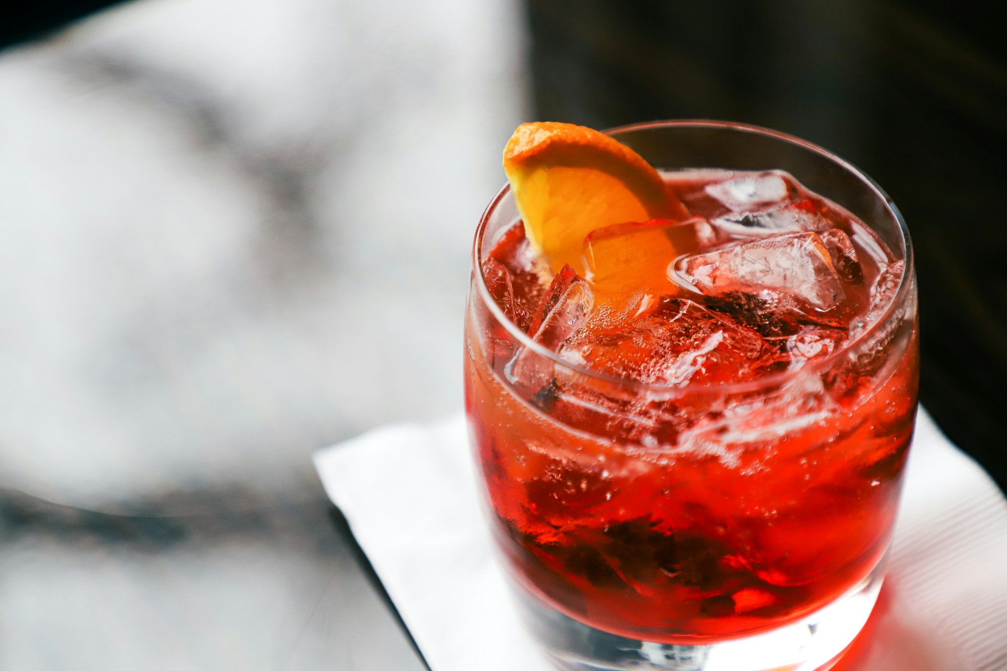 Close up of a virgin Negroni on a napkin.
