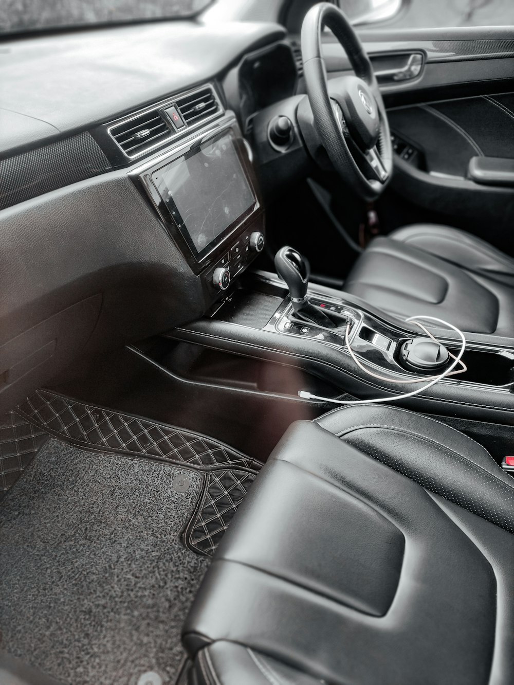 El interior de un coche con asientos de cuero negro