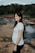 A happy pregnant woman practicing meditation outdoors.