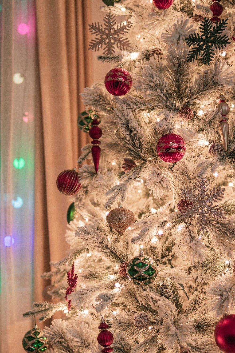 a white christmas tree with red and green ornaments