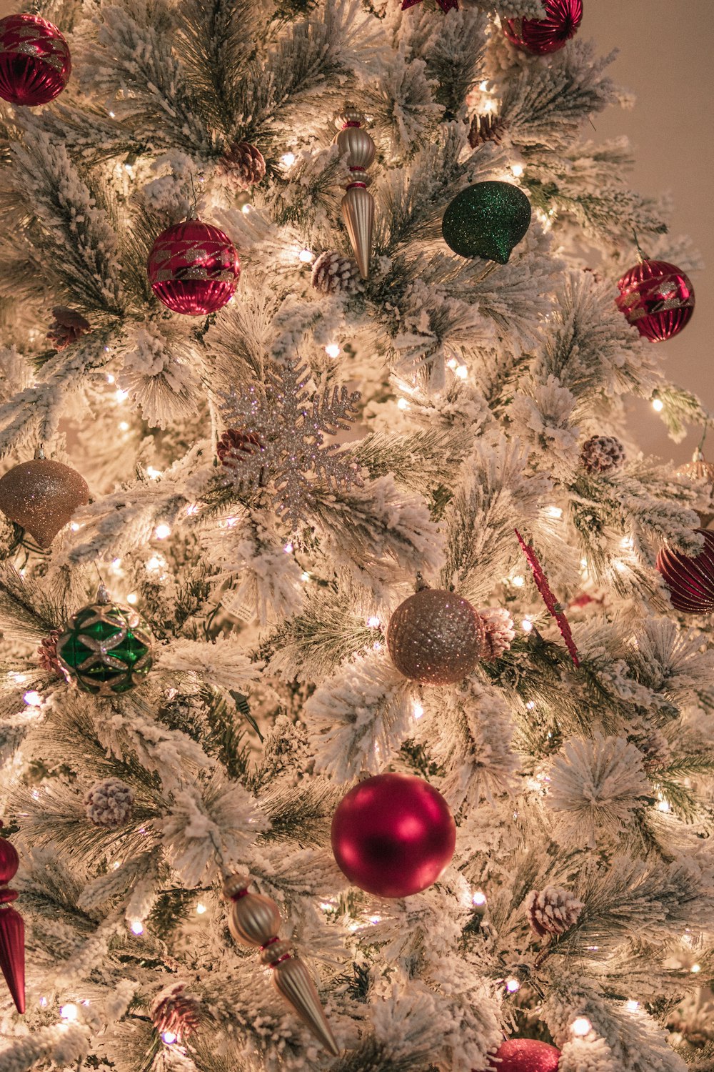 a white christmas tree with red and green ornaments